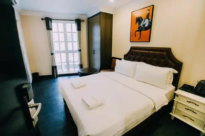 a bedroom with a large bed with two white pillows at Hotel Venice in Kuala Lumpur