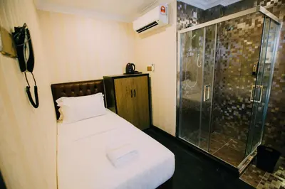 a bedroom with a shower and a bed and a phone at Hotel Venice in Kuala Lumpur