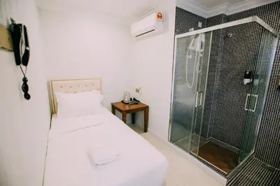 a bedroom with a shower and a bed with a glass door at Hotel Venice in Kuala Lumpur