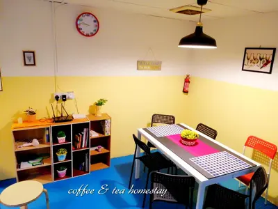 a dining room with a table and chairs and a clock at Coffee & Tea Homestay 2 in Kuala Lumpur