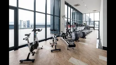 a gym with a row of treadmills and exercise bikes at 7 mins KLCC next to Hospital Gleneagle in Kuala Lumpur