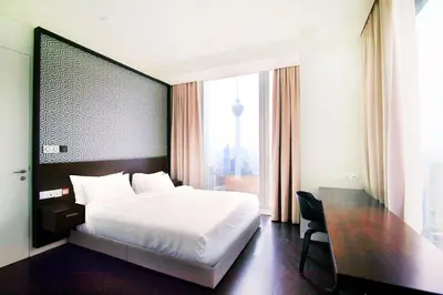 a bedroom with a bed and a desk and a window at Tropicana The Residences KLCC by Vale Pine in Kuala Lumpur