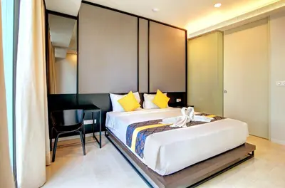 a bedroom with a large bed with a desk and a table at Tropicana The Residences KLCC by Vale Pine in Kuala Lumpur