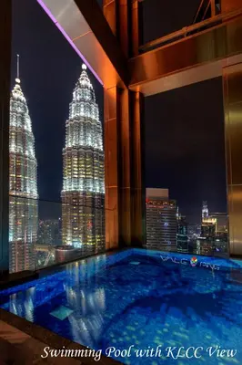 a swimming pool with a view of the city at night at Tropicana The Residences KLCC by Vale Pine in Kuala Lumpur