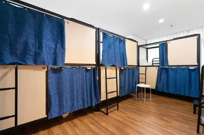 a row of prison cells with blue curtains at Amethyst KLCC in Kuala Lumpur