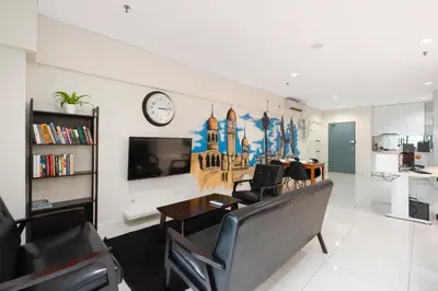 a living room with a couch and a clock on a wall at Amethyst KLCC in Kuala Lumpur