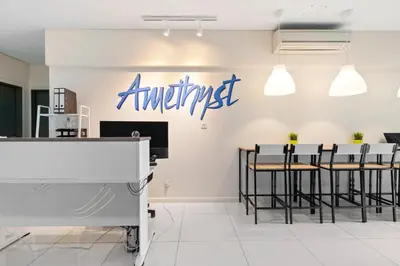 a restaurant with chairs and a sign on the wall at Amethyst KLCC in Kuala Lumpur