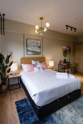 a bedroom with a large white bed with pink pillows at Urban Living Residence in Kuala Lumpur