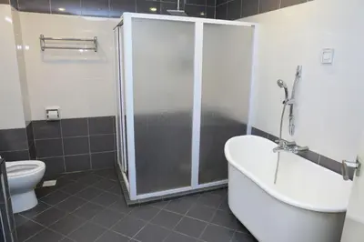 a bathroom with a shower and a tub and a toilet at Akar Hotel Kampung Baru in Kuala Lumpur