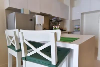 a kitchen with a counter with two chairs and a refrigerator at Kisetsu no ie, KLCC Kuala Lumpur in Kuala Lumpur