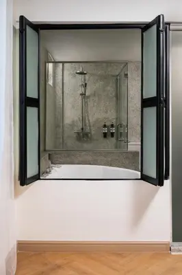 a mirror in a bathroom with a bath tub at BRYQS Hotel in Kuala Lumpur