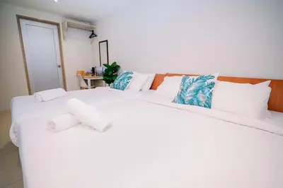 two white beds in a room with at Swing & Pillows - KL Pekeliling in Kuala Lumpur