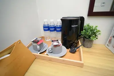 a wooden tray with water bottles and cups on a table at Swing & Pillows - KL Pekeliling in Kuala Lumpur