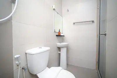 a white bathroom with a toilet and a shower at Swing & Pillows - KL Pekeliling in Kuala Lumpur