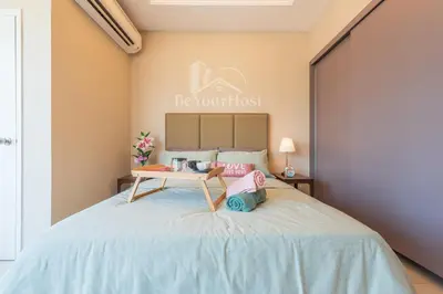 a bedroom with a bed with a table on it at Dorsett Residences Sri Hartamas [5 Star Suites] in Kuala Lumpur