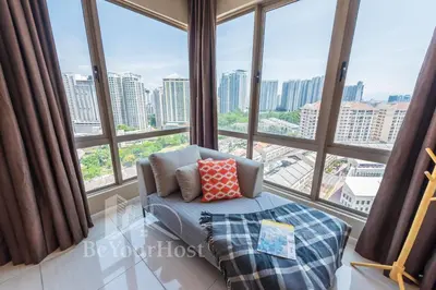 a room with large windows and a chair in front at Dorsett Residences Sri Hartamas [5 Star Suites] in Kuala Lumpur