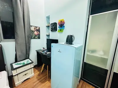 a small room with a refrigerator and a desk at Taragon Apartment - KL ,Malaysia in Kuala Lumpur