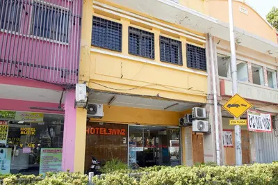 a yellow building with a street sign in front of it at Hotel 3Winz Chow Kit Kuala Lumpur in Kuala Lumpur