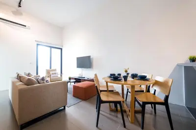 a living room with a table and a couch at Establishment Bangsar By Sleepy Bear in Kuala Lumpur