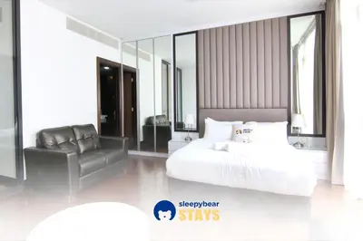 a bedroom with a white bed and a chair at Ken Bangsar By Sleepy Bear in Kuala Lumpur