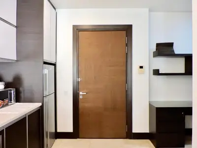 a kitchen with a wooden door in a room at Ken Bangsar By Sleepy Bear in Kuala Lumpur