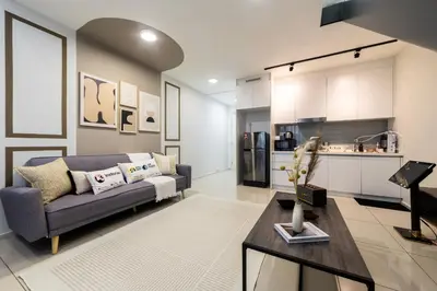 a living room with a couch and a kitchen at Eko Cheras By Sleepy Bear in Kuala Lumpur