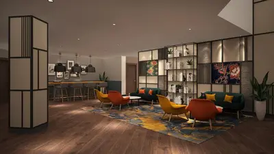 a lobby with chairs and a table and a bar at ACES Hotel Kuala Lumpur in Kuala Lumpur