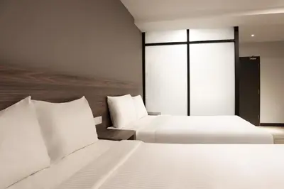 a hotel room with two beds and a window at ACES Hotel Kuala Lumpur in Kuala Lumpur