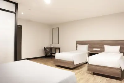 a hotel room with two beds and a desk at ACES Hotel Kuala Lumpur in Kuala Lumpur