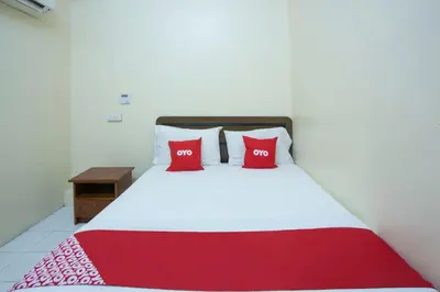a bed with two red pillows on top of it at Hotel O Perfect Class Hotel in Kuala Lumpur