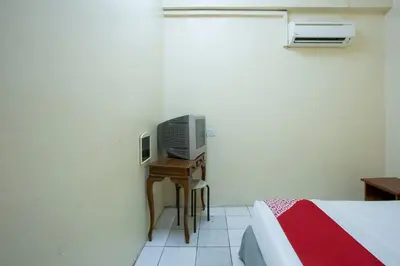 a bedroom with a bed and a television on a table at Hotel O Perfect Class Hotel in Kuala Lumpur