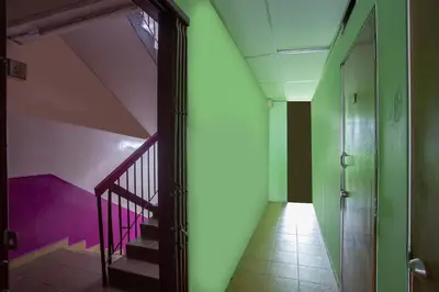 a hallway with stairs and a green and purple wall at Hotel O Perfect Class Hotel in Kuala Lumpur