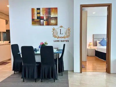 a dining room with a table and black chairs at Luxe Suites at Vortex KLCC in Kuala Lumpur