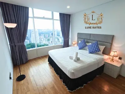 a hotel room with a large bed with blue pillows at Luxe Suites at Vortex KLCC in Kuala Lumpur