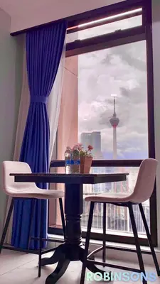 a table and two chairs in front of a window at Serviced Apartments at Times Square Kuala Lumpur by Robinsons in Kuala Lumpur
