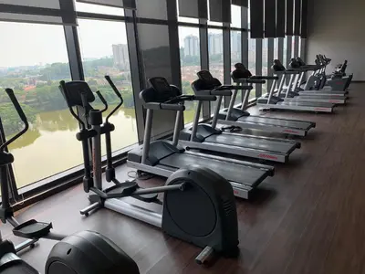 a row of treadmills in a gym with windows at 2 bedroom apartment at 28 Boulavard in Kuala Lumpur