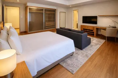 a bedroom with a bed and a couch and a television at Cormar Suites Kuala Lumpur in Kuala Lumpur