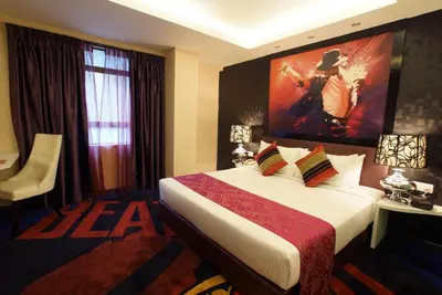 a hotel room with a bed with a painting on the wall at Kingston Hotel 3 - Kuala Lumpur in Kuala Lumpur
