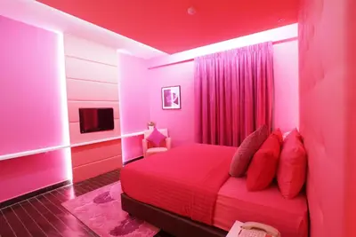 a pink bedroom with a bed and a tv at Kingston Hotel 3 - Kuala Lumpur in Kuala Lumpur