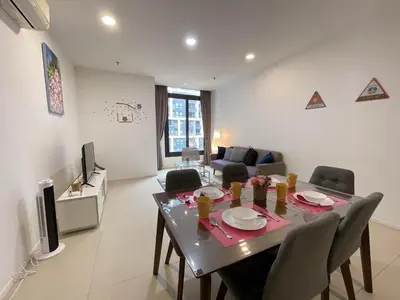 a dining room with a table and chairs and a living room at ARCORIS, MONT KIARA by MK HOME in Kuala Lumpur