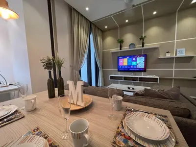 a living room with a table and a tv at ARCORIS, MONT KIARA by MK HOME in Kuala Lumpur