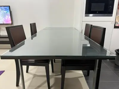 a glass table with chairs and a television in a room at ARCORIS, MONT KIARA by MK HOME in Kuala Lumpur