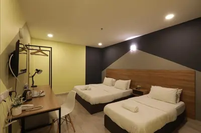 a hotel room with two beds and a desk at T-hotel Mont Kiara in Kuala Lumpur