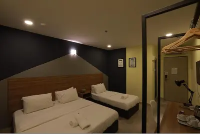 a hotel room with two beds and a mirror at T-hotel Mont Kiara in Kuala Lumpur