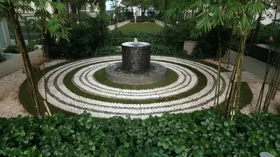 a fountain in the middle of a garden at Infinity KLCC Pool at M City Ampang in Kuala Lumpur