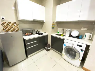 a kitchen with a washer and a washing machine at Lily and Loft - KL Gateway Bangsar LRT, WIFI, Netflix in Kuala Lumpur