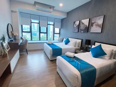 a hotel room with two beds and a desk at Ceylonz Starlight Suites Bukit Bintang in Kuala Lumpur