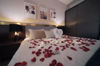 a bed covered in red rose petals and a couple of towels at Ceylonz Starlight Suites Bukit Bintang in Kuala Lumpur