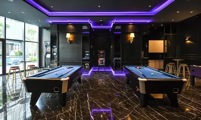 a billiard room with two pool tables and purple lighting at Star Suites KLCC in Kuala Lumpur