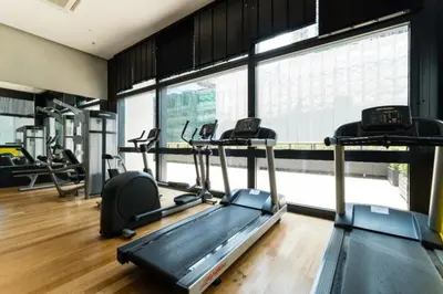a gym with several treadmills and elliptical machines at Arcoris Mont Kiara in Kuala Lumpur